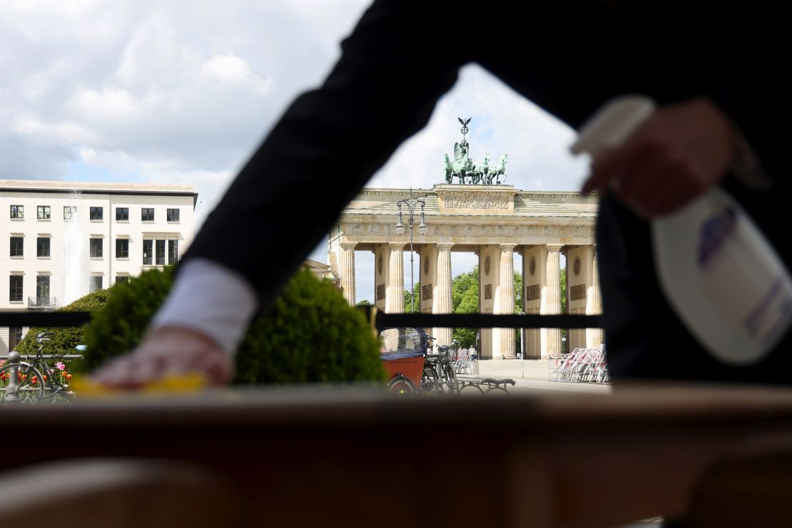 A waiter cleans a restaurant table ahead of reopening in Berlin, Germany, on May 21, 2021. 