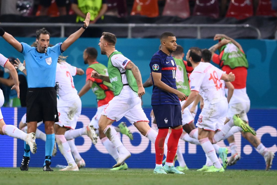 Switzerland players celebrate after Kylian Mbappé misses the crucial penalty.
