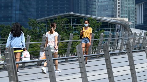 People walk along a pedestrian bridge at the financial business district in Singapore on June 25, 2021. (Photo by Roslan RAHMAN / AFP) (Photo by ROSLAN RAHMAN/AFP via Getty Images)