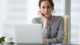 underscored confused concerned woman looking at laptop