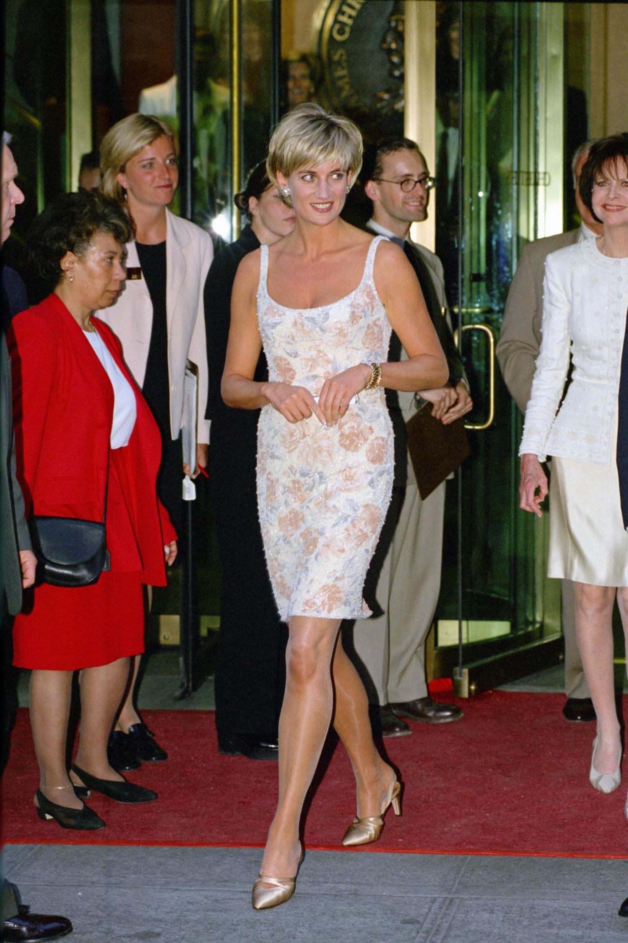 Princess Diana wearing a Catherine Walker mini dress to the launch of a 1997 Christie's auction, where she sold many of her most iconic outfits.