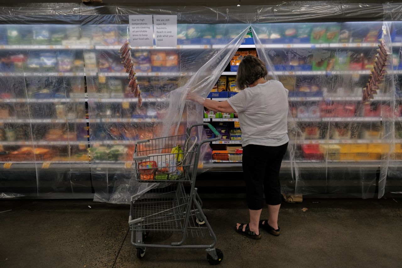 A woman shops for perishable items at a grocery store in Portland on Monday. The food was covered with a layer of plastic to keep in the cool air.