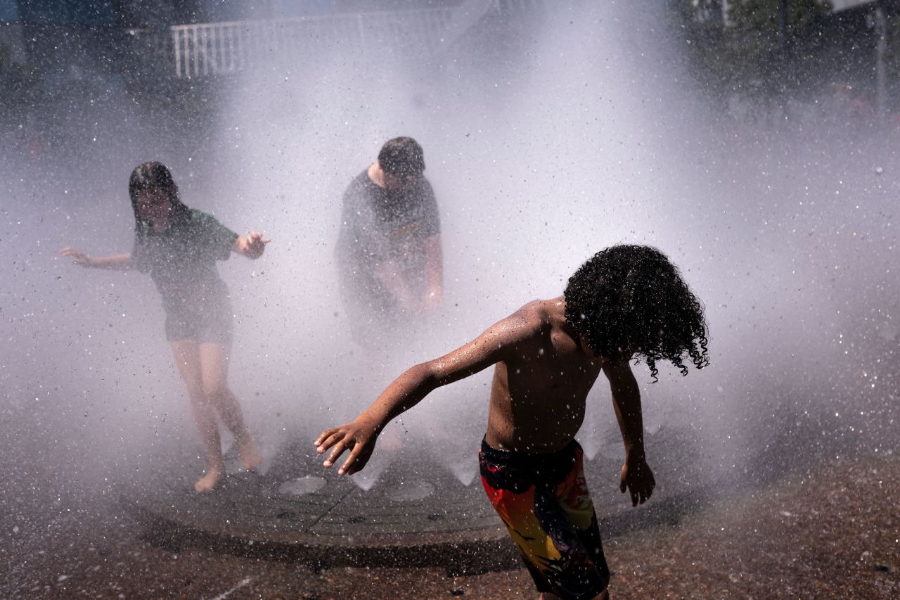 Children cool off in the Salmon Springs Fountain in Portland on Sunday.