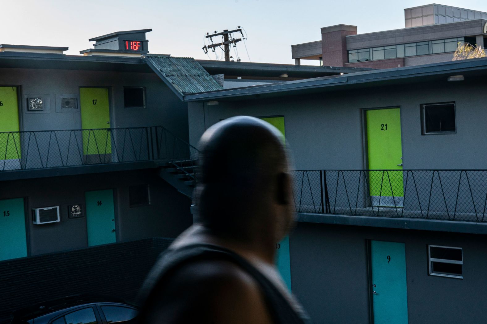 Everett Clayton looks at a digital thermometer that reads 116 degrees while walking to his apartment in Everett, Washington, on Sunday.