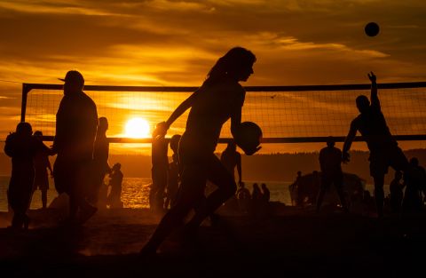 People play beach volleyball at Seattle's Golden Gardens Park as the sun sets on Thursday.