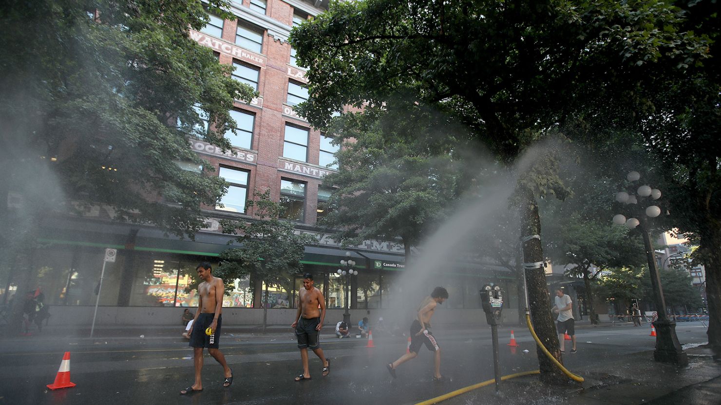 A temporary misting station in Vancouver cools residents amid the extreme heat.