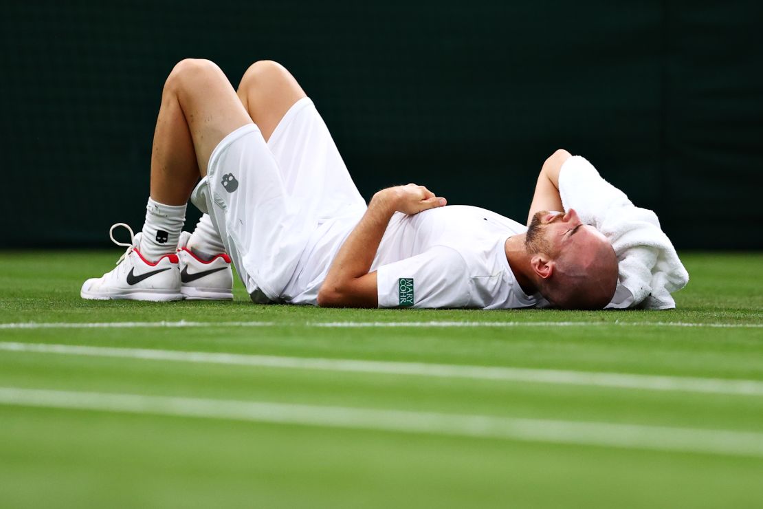 Adrian Mannarino of France reacts as he goes down with an injury in his first-round match against Roger Federer.