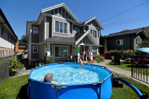 Emily Beers and Craig Patterson cool off Sunday in a pool set up in front of Patterson's home in Vancouver, British Columbia.