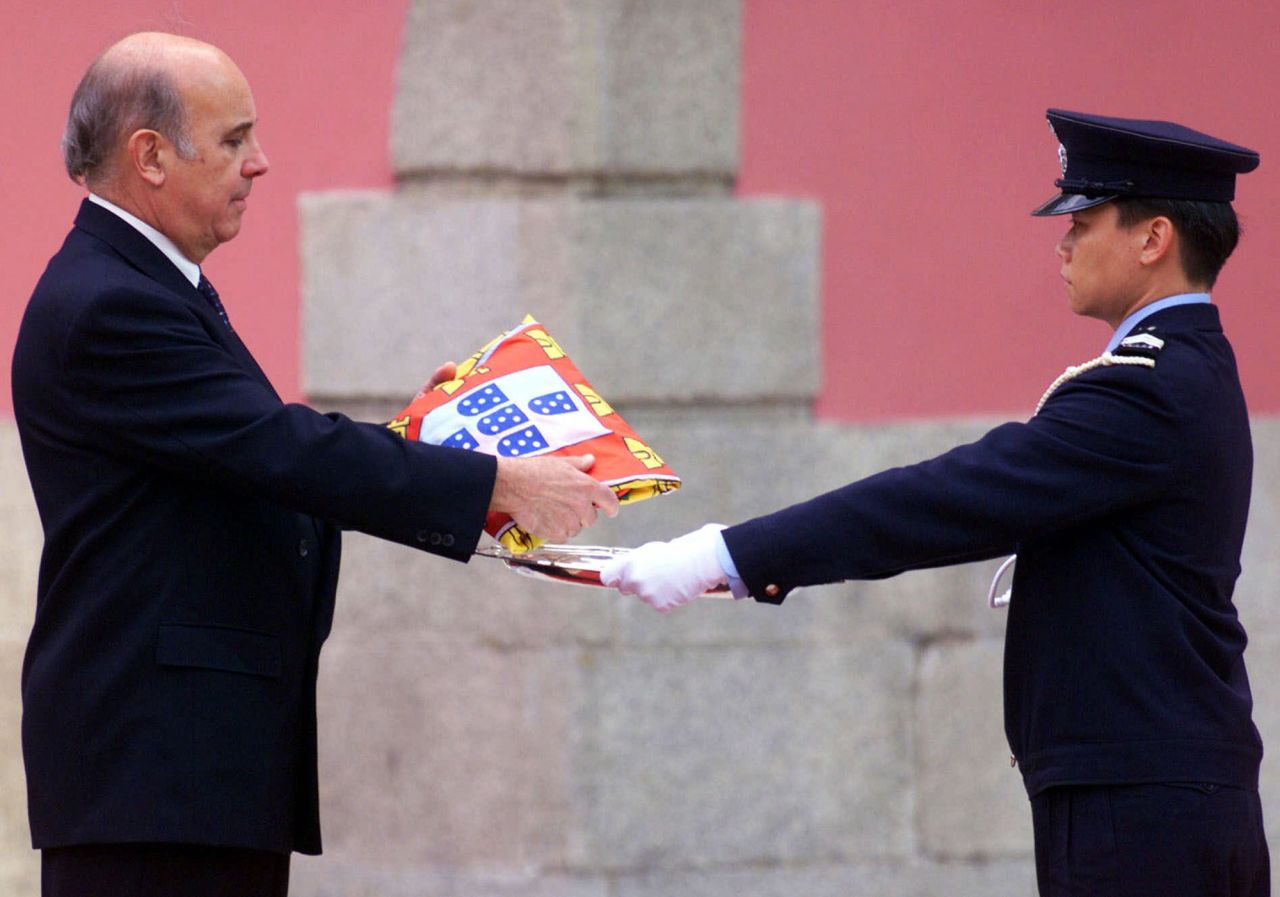 Outgoing Macao Gov. Vasco Joaquim Rocha Vieira, left, is presented with a Portuguese flag before Portugal formally handed the colony back to China in 1999, ending 442 years of colonial rule. Macao, like Hong Kong, is a special administrative region that has a separate governing system from mainland China. It was Europe's oldest and last colony in Asia.