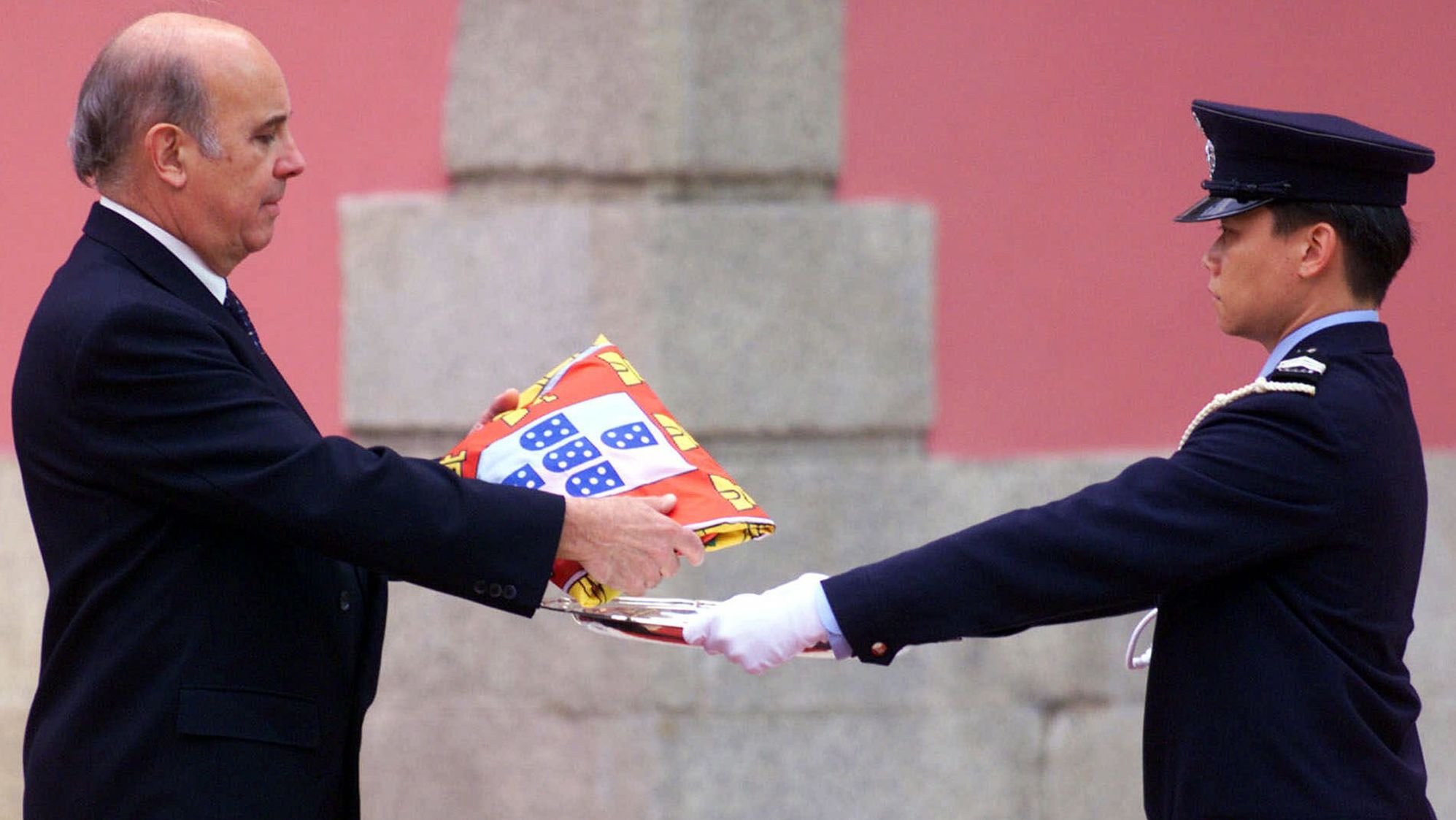 Outgoing Macao Gov. Vasco Joaquim Rocha Vieira, left, is presented with a Portuguese flag before Portugal formally handed the colony back to China in 1999, ending 442 years of colonial rule. Macao, like Hong Kong, is a special administrative region that has a separate governing system from mainland China. It was Europe's oldest and last colony in Asia.