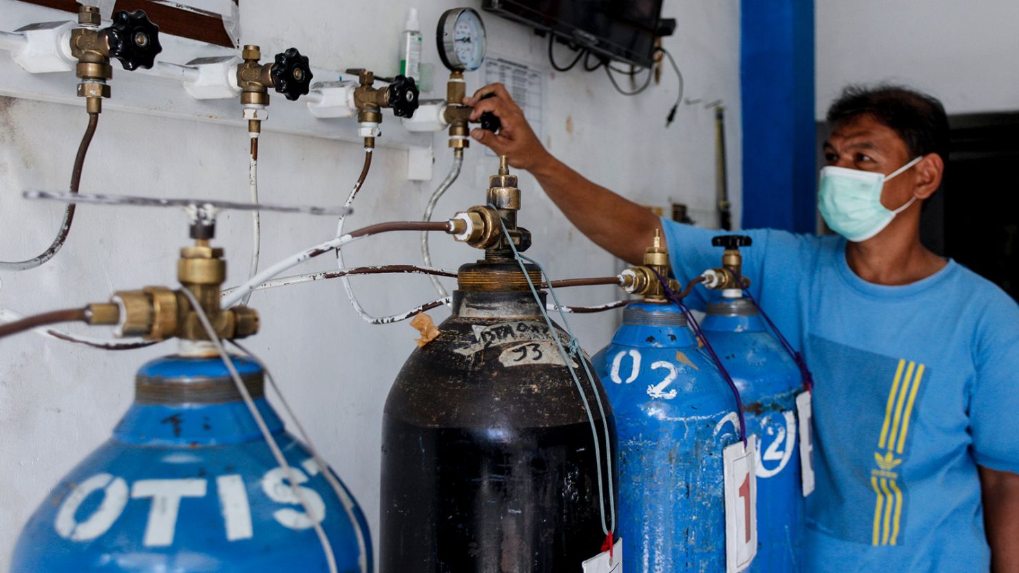 A worker refills oxygen cylinders for treating patients as the demand for medical oxygen increased in Bogor, West Java, Indonesia on June 25, 2021.