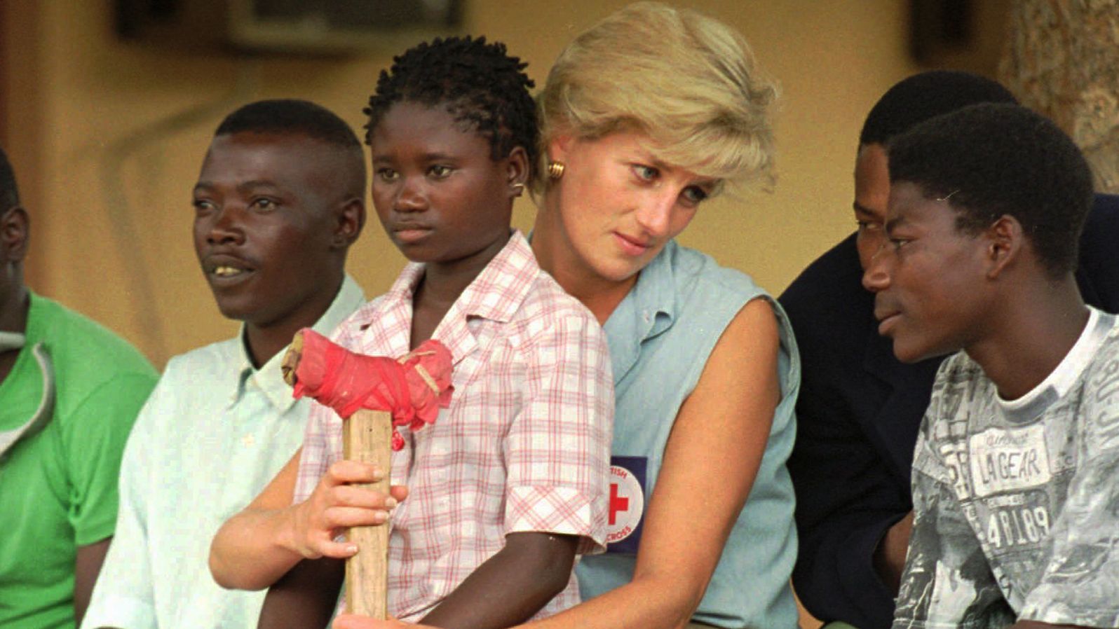 Diana talks to amputees in Angola, where she traveled in January 1997 to bring attention to the anti-land mine campaign of the International Red Cross. Sitting on her lap is Sandra Thijica, a 13-year-old who lost her left leg to a land mine.