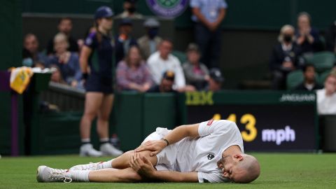 Mannarino holds his knee after slipping against Federer.