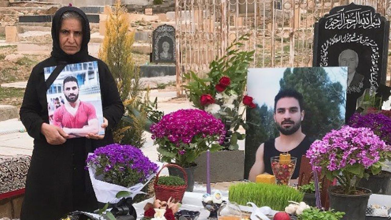 Navid's mother (left) stands by Navid's grave in March 2021 in Shiraz, Iran.