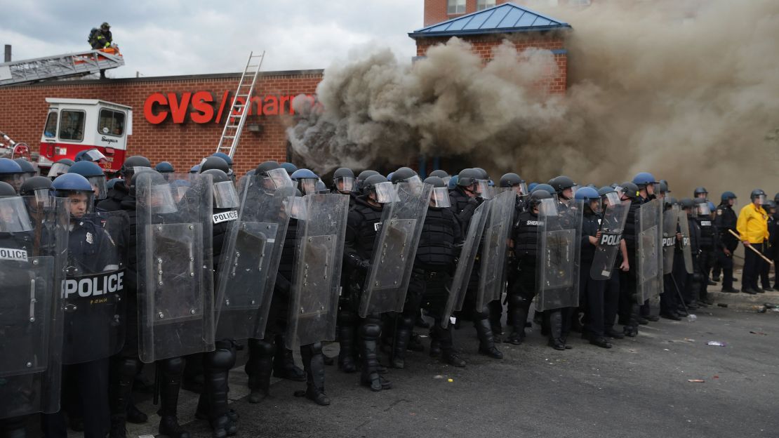 Baltimore Police form a perimeter around a CVS pharmacy that was looted and burned during protests after the funeral of Freddie Gray on April 27, 2015, in Baltimore. 