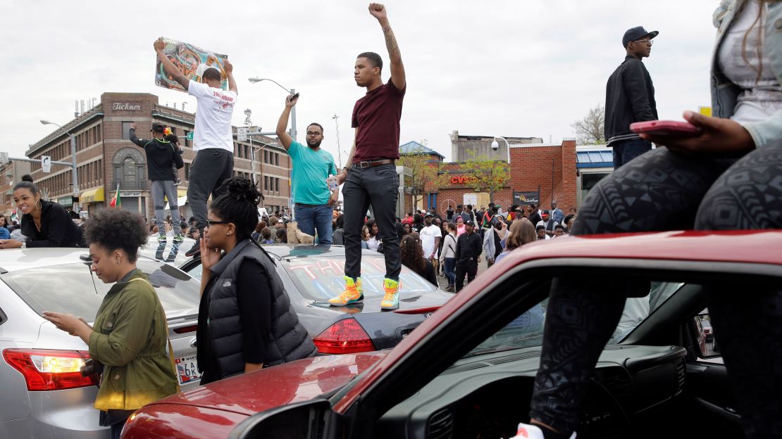 Protesters stand on cars near the intersection of in Baltimore on May 1, 2015, the day of the announcement of charges against the police officers involved in Freddie Gray's arrest.