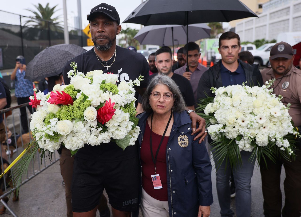 NBA basketball player Udonis Haslem, left, and Miami-Dade County Mayor Daniella Levine Cava arrive to pay their respects at a memorial near the building on June 30.