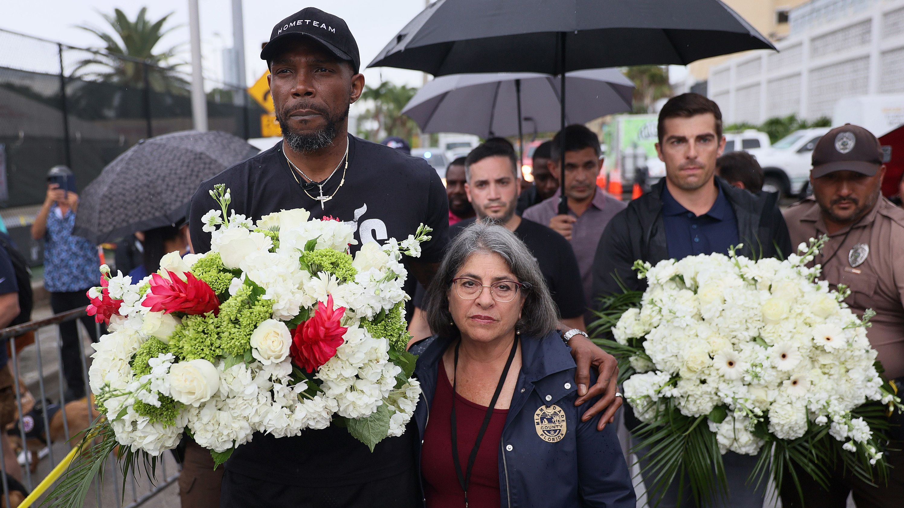 NBA basketball player Udonis Haslem, left, and Miami-Dade County Mayor Daniella Levine Cava arrive to pay their respects at a memorial near the building on June 30.