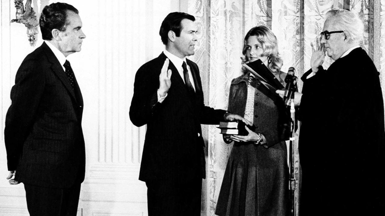 Donald Rumsfeld, second from right, new United Nations ambassador to the North Atlantic Treaty Organization, takes oath of office from Chief Justice Warren E. Burger, right, during a ceremony on February 2,1973, at the White House. President Richard M. Nixon looks on at left and Mrs. Joyce Rumsfeld holds a Bible  for her husband.