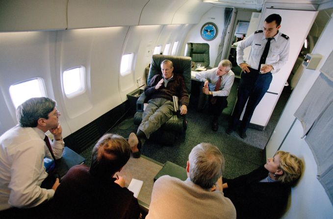 Rumsfeld talks to staff members aboard a plane en route to Saudi Arabia in October 2001.