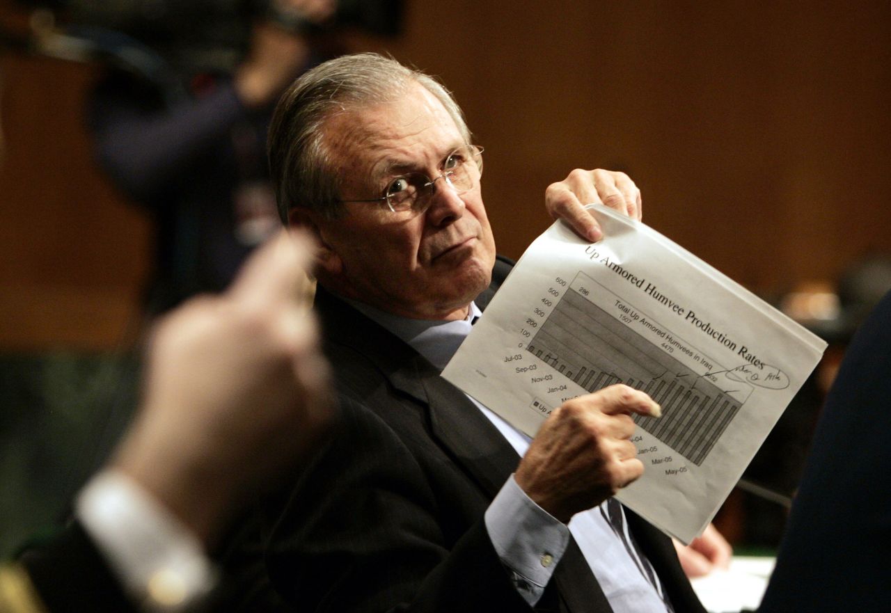 Rumsfeld motions to an aide to display a chart detailing production of armored Humvees as he is questioned during his testimony to the Senate Appropriations Committee in February 2005.