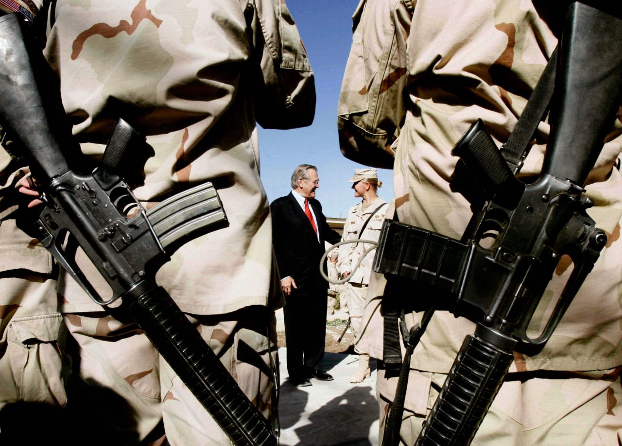 US soldiers from the 173rd Airborne Brigade wait to have their picture taken with Rumsfeld in Kandahar, Afghanistan, in December 2005.