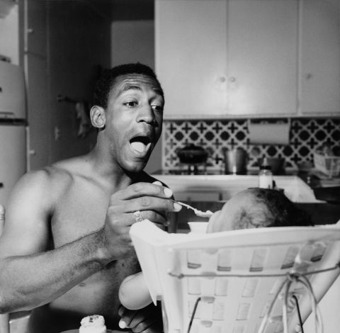 Cosby feeds one of his children circa 1965. Cosby first made his name with his comedic storytelling, which were often based on his own childhood experiences.
