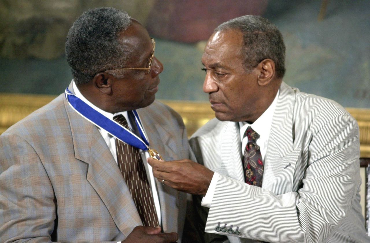 Cosby sits with baseball great Hank Aaron after they both received the Presidential Medal of Freedom in 2002. The medal is America's highest civilian award.