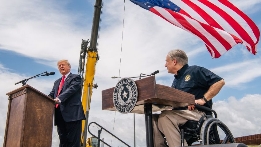 PHARR, TEXAS - JUNE 30: Texas Gov. Greg Abbott listens to former President Donald Trump's address during a tour to an unfinished section of the border wall on June 30, 2021 in Pharr, Texas. Gov. Abbott has pledged to build a state-funded border wall between Texas and Mexico as a surge of mostly Central American immigrants crossing into the United States has challenged U.S. immigration agencies. So far in 2021, U.S. Border Patrol agents have apprehended more than 900,000 immigrants crossing into the United States on the southern border.  (Photo by Brandon Bell/Getty Images)