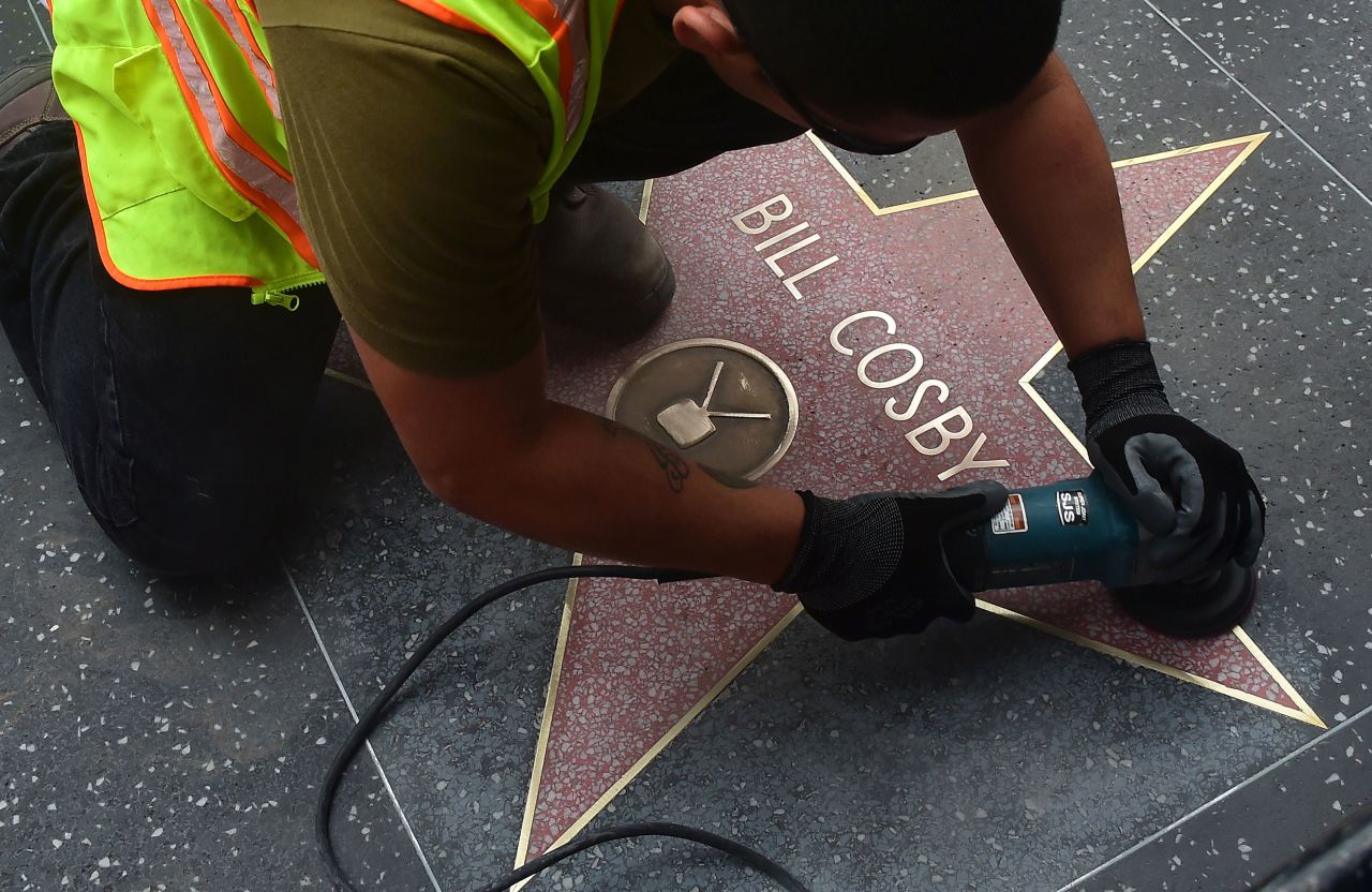 A worker cleans actor Cosby's star on the Hollywood Walk of Fame after someone vandalized it in December 2014. This was after some of the allegations against Cosby had come to light.