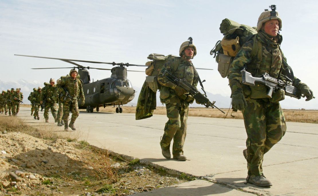 US Army soldiers from the 10th Mountain and the 101st Airborne units disembark from a Chinook helicopter March 11, 2002 as they return to Bagram airbase from the fighting in eastern Afghanistan. 