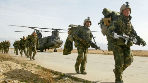 US Army soldiers from the 10th Mountain and the 101st Airborne units disembark from a Chinook helicopter March 11, 2002 as they return to Bagram airbase from the fighting in eastern Afghanistan. 
