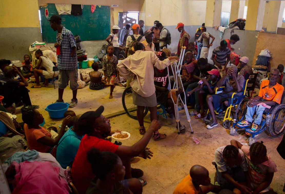 A group of blind and disabled people eat at a refuge for displaced persons after armed gangs set their homes on fire in Port-au-Prince, on June 24, 2021.