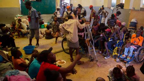 A group of blind and disabled people eat at a refuge for displaced persons after armed gangs set their homes on fire in Port-au-Prince, on June 24, 2021.