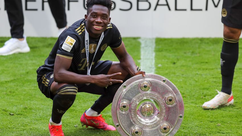 MUNICH, GERMANY - MAY 22: Alphonso Davies of Bayern Muenchen lifts the Bundesliga Meisterschale Trophy  following the Bundesliga match between FC Bayern Muenchen and FC Augsburg at Allianz Arena on May 22, 2021 in Munich, Germany. After the Bavarian cabinet decided on first relaxations for outdoor events, the current Corona situation allows FC Bayern to have its last match of the season in front of 250 spectators in the Allianz Arena. Of these, 100 tickets are given to people from the health sector selected by the Ministry of Health. (Photo by Stefan Matzke - sampics/Corbis via Getty Images)