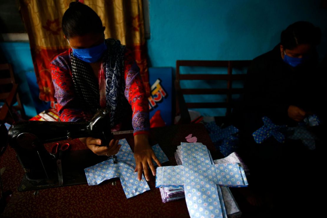 A volunteer stitches cloth to make reusable sanitary pads at Sinamangal in Kathmandu, Nepal.