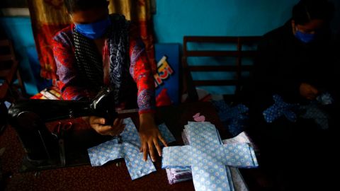 A volunteer stitches cloth to make reusable sanitary pads at Sinamangal in Kathmandu, Nepal.