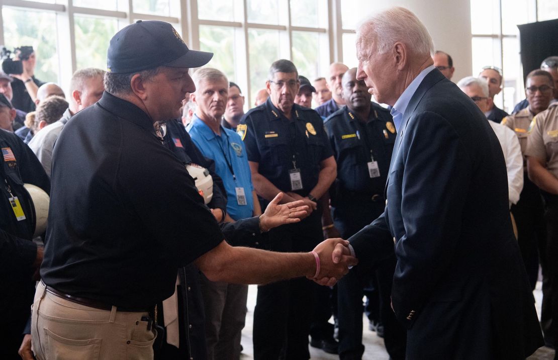 US President Joe Biden(R) shakes hands with Jimmy Patronis, Florida's Chief Financial Officer, as he meets with first responders to the collapse of the 12-story Champlain Towers South condo building in Surfside, during a meeting with them in Miami Beach, Florida, July 1, 2021. - President Joe Biden flew to Florida on Thursday to "comfort" families of people killed or still missing in the rubble of a beachfront apartment building, where hopes of finding survivors had all but evaporated. Biden and First Lady Jill Biden left the White House early for the flight to Miami, and then traveled by motorcade to nearby Surfside, where the death toll in the tragedy now stands at 18, and more than 140 still unaccounted for. (Photo by SAUL LOEB/AFP via Getty Images)