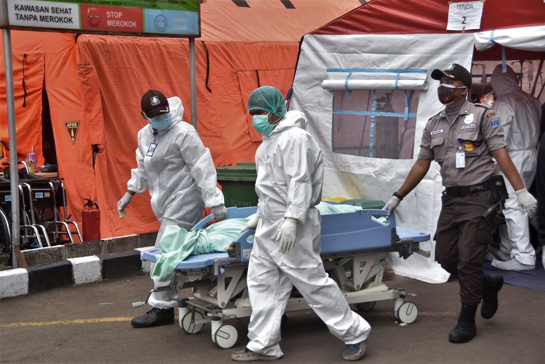 Medical staff carry a body of a patient who died of Covid-19 at a hospital in Bekasi on July 1, 2021.