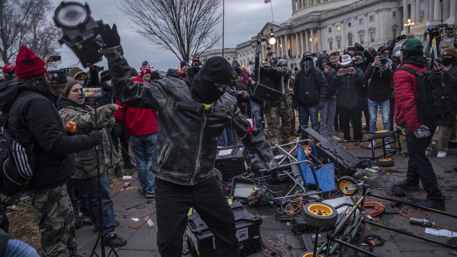 Demonstrators destroy broadcast video equipment outside the US Capitol in n Washington, January 6, 2021. The person at the center of the photo was later identified as Joshua Haynes, according to a criminal complaint.