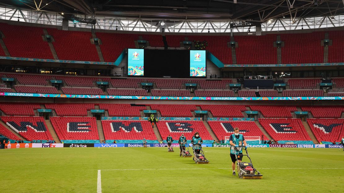Groundkeepers work on the grass at Wembley Stadium after a match.