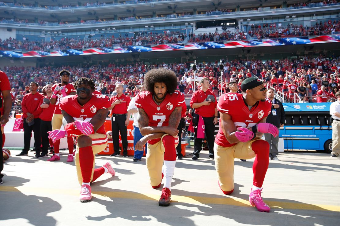 Colin Kaepernick, center, and two other members of the San Francisco 49ers kneel during the national anthem prior to a game against the Tampa Bay Buccaneers on October 23, 2016, in Santa Clara, California. 