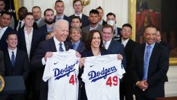 US President Joe Biden and Vice President Kamala Harris hold up Los Angeles Dodgers team baseball jerseys as they welcome the 2020 World Series Champions during a ceremony in the East Room of the White House in Washington, DC on July 2, 2021.