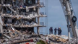TOPSHOT - Members of the South Florida Urban Search and Rescue team look for possible survivors in the partially collapsed 12-story Champlain Towers South condo building on June 27, 2021 in Surfside, Florida. - The death toll after the collapse of a Florida apartment tower has risen to nine, the local mayor said on June 27, 2021, more than three days after the building pancaked as residents slept. "We were able to recover four additional bodies in the rubble... So I am confirming today that the death toll is at nine," Miami-Dade County mayor Daniella Levine Cava told reporters in Surfside, near Miami Beach, adding that one victim had died in hospital. "We've identified four of the victims and notified next of kin." (Photo by Giorgio Viera / AFP) (Photo by GIORGIO VIERA/AFP via Getty Images)