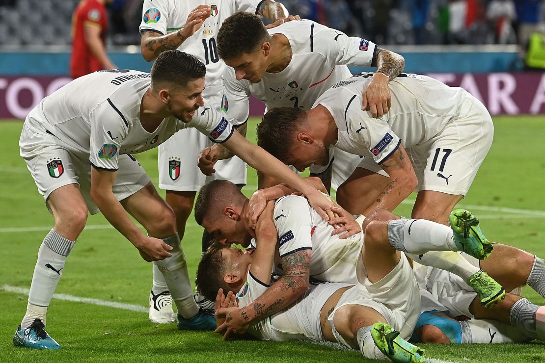 Nicolo Barella is mobbed by his teammates after scoring Italy's opening goal.