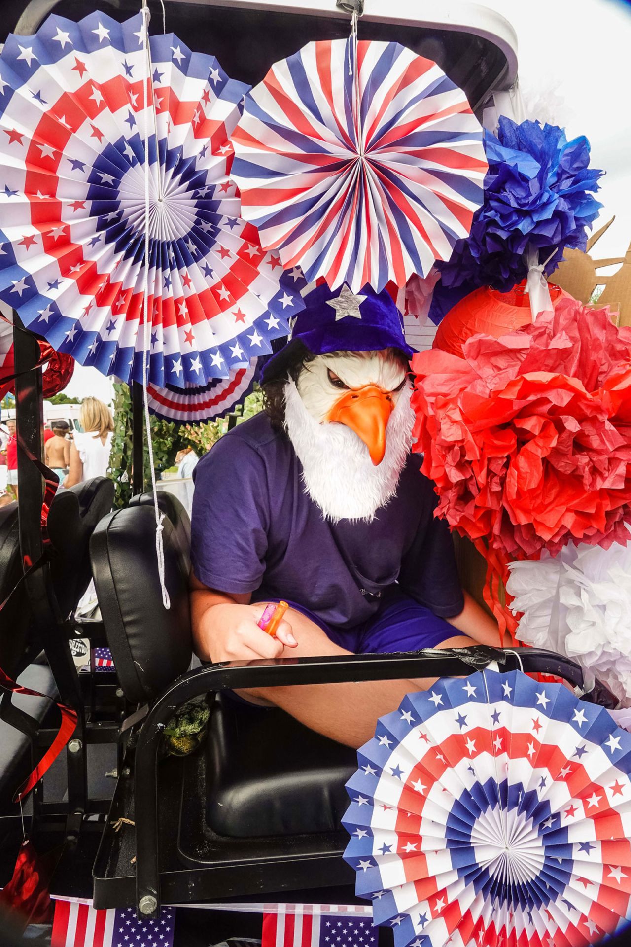 A teenager wearing a Bald Eagle mask looks out from a decorated golf cart during the annual Bicycle and Golf cart parade celebrating Independence Day on July 3 in Sullivan's Island, South Carolina.