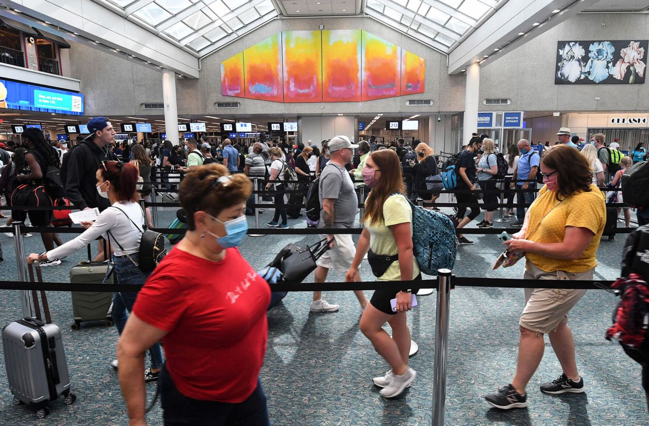 Travelers wait in line for TSA security screening at Orlando International Airport as the July 4th holiday weekend begins. 
