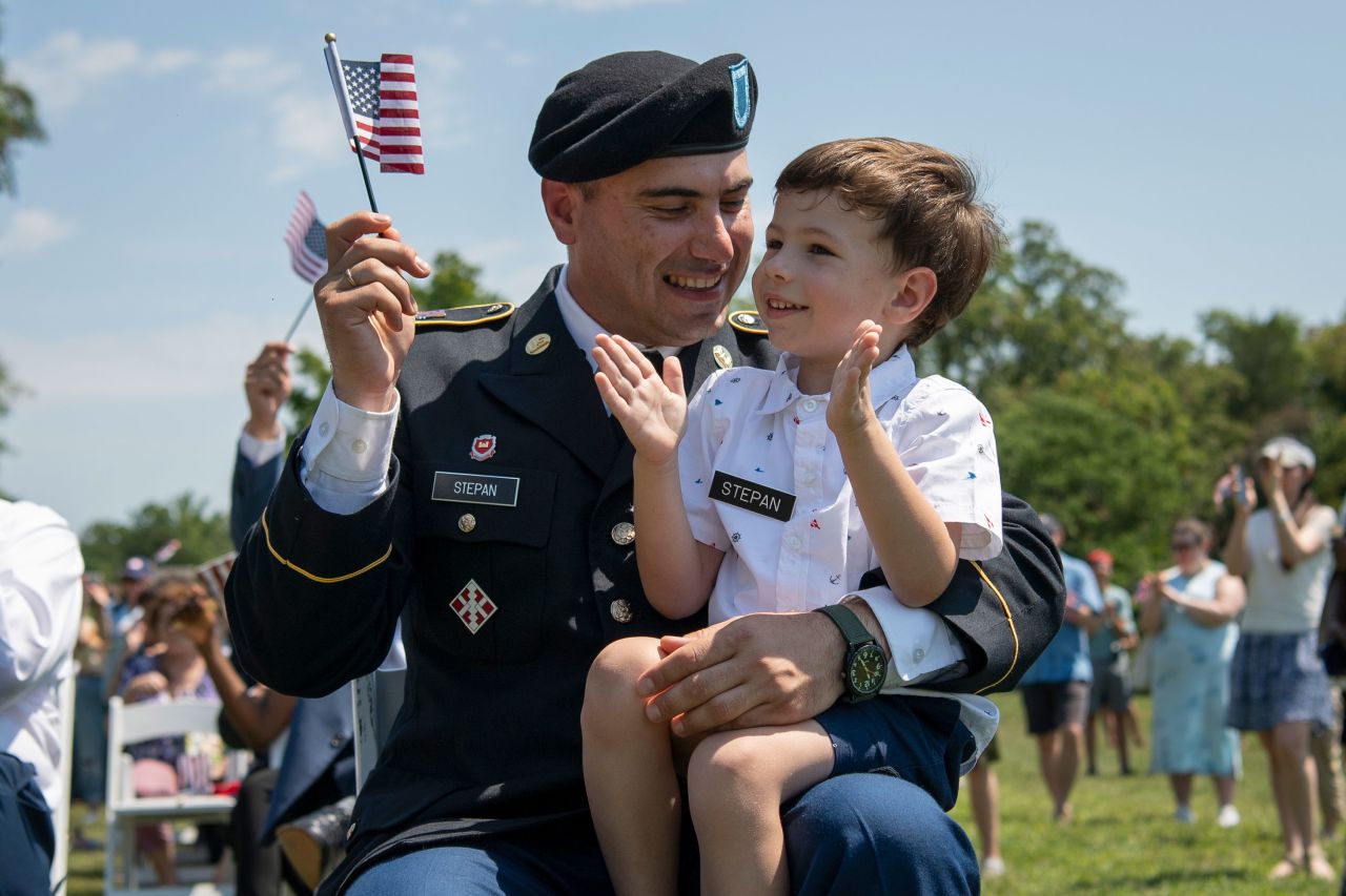 Alexandru Stepan holds his son, Daniel, during a naturalization ceremony at George Washington's Mount Vernon in Virginia, on Sunday, July 4.