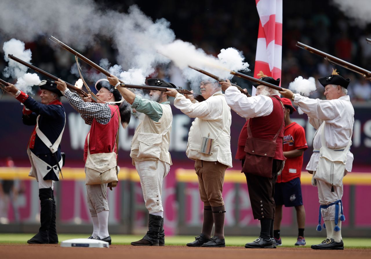 Men dressed as Revolutionary War soldiers fire a volley prior to the baseball game between the Atlanta Braves and Miami Marlins on Sunday, in Atlanta.