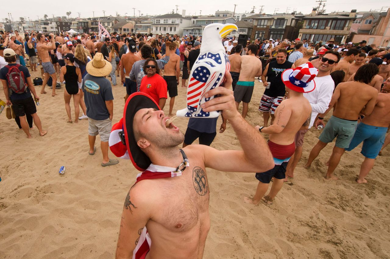 A participant chugs beer during the 47th annual Hermosa Beach Ironman competition in California. Competitors run a mile, paddle a surfboard a mile and chug a six pack of beer.
